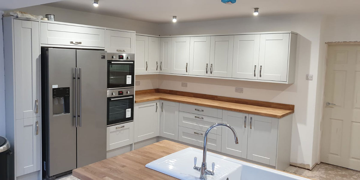 Light grey fitted kitchen with wooden worktops installed by MW Construction in Trentham, Stoke-on-Trent